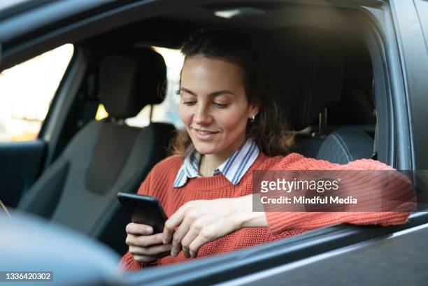 porträt eines lächelnden männlichen reifen erwachsenen, der ein mobiltelefon benutzt, während er auf dem fahrersitz eines autos sitzt - petrol paying stock-fotos und bilder