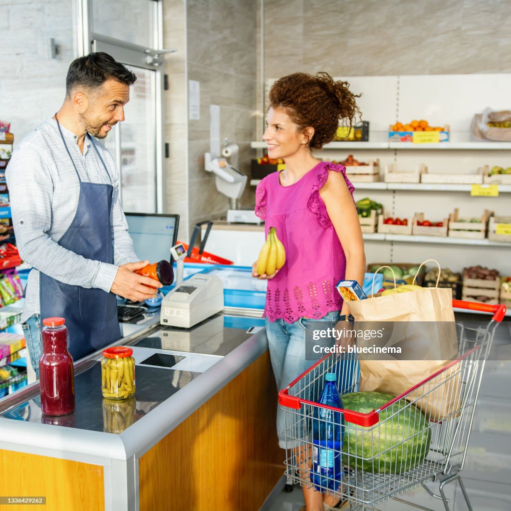 Cashier Scanning Products At A Grocery Store Wearing High-Res Stock ...