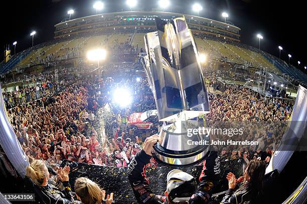 Tony Stewart, driver of the Office Depot/Mobil 1 Chevrolet, celebrates with the trophy in Victory Lane after winning the NASCAR Sprint Cup Series...