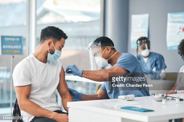 shot of a woman receiving an injection at a covid-19 vaccination centre - infection control stock pictures, royalty-free photos & images