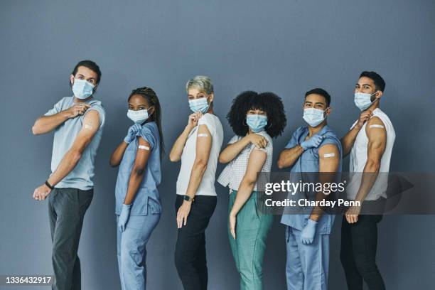 shot of a group of people wearing plasters after getting the covid-19 vaccine - person studio shot stock pictures, royalty-free photos & images