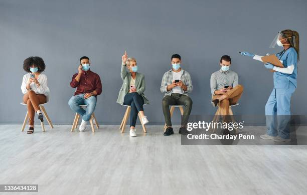 shot of a group of people waiting to get the vaccine at work in a modern office - lining up for vaccine stock pictures, royalty-free photos & images