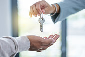Shot of an unrecognizable person giving the keys to a house to a buyer