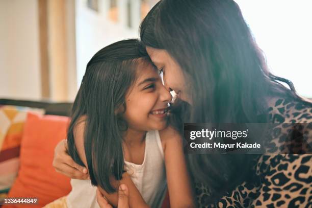 close up of mother and daughter embracing each other - indian mom stock-fotos und bilder