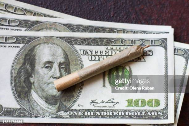 dollar bill and homemade cigarette on a dark table - cannabis business stock pictures, royalty-free photos & images