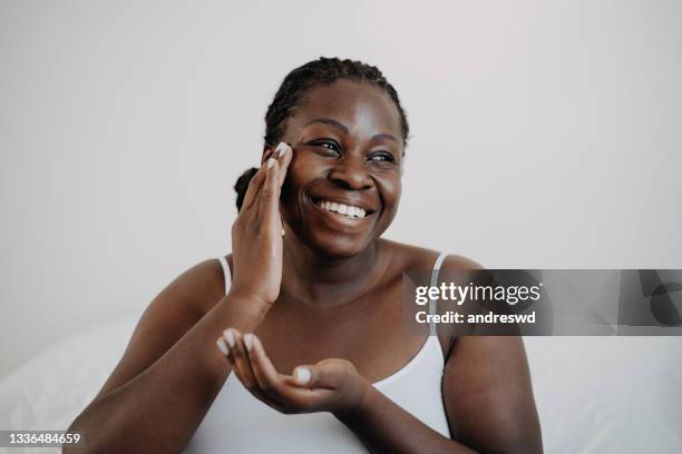 skin care using cosmetic skin cream woman with black skin - woman portrait skin stockfoto's en -beelden