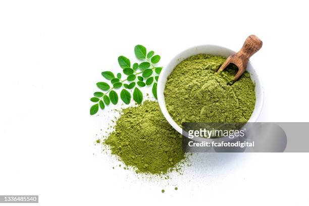 matcha tea powder and leaves on white background - green tea leaves stockfoto's en -beelden