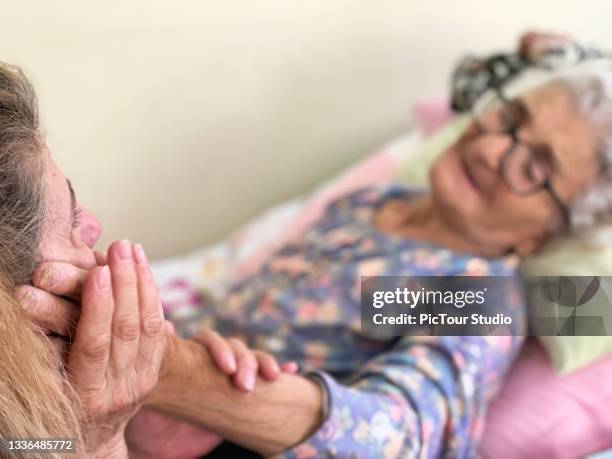 sick senior adult looking at her daughter - old lady crying out for help stock pictures, royalty-free photos & images