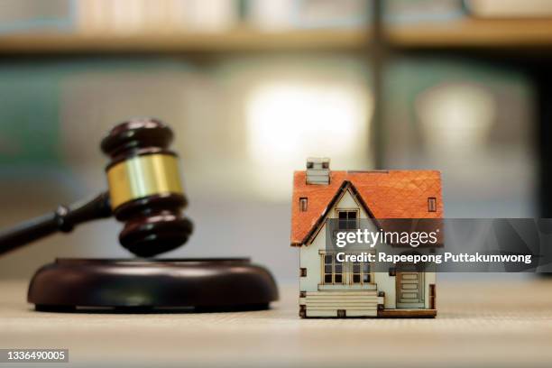 real estate law concept. judge gavel and house model on table - judges table stock pictures, royalty-free photos & images