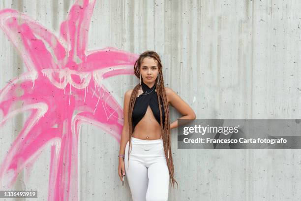 woman with braided hair standing in front of a colorful mural - mural portrait stock pictures, royalty-free photos & images