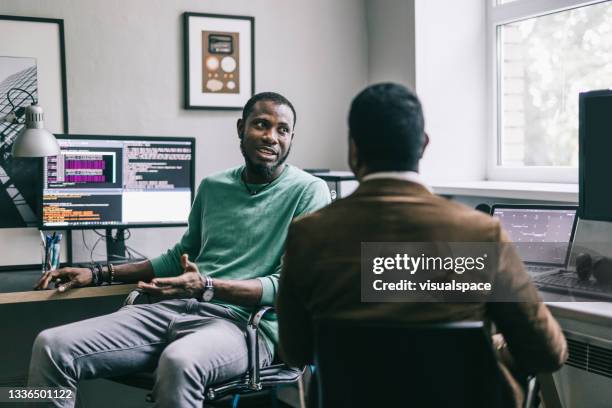 compañeros de trabajo que tienen una charla en el trabajo - programador de informática fotografías e imágenes de stock