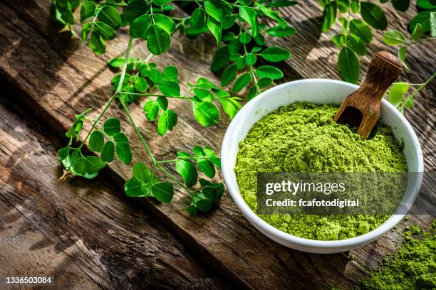 nutritional supplement: moringa powder on rustic table - drumstick stock pictures, royalty-free photos & images