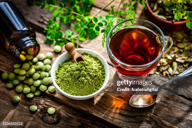 matcha-tee, moringa-pulver und pillen auf rustikalem tisch - chinese medicine stock-fotos und bilder