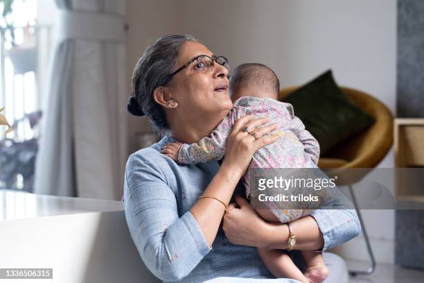 happy grandmother with baby grandson at home - grandma sleeping stockfoto's en -beelden