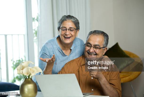 altes paar, das spaß mit dem laptop zu hause hat - indian old man stock-fotos und bilder