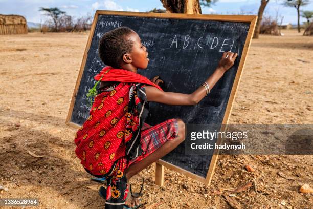 kleines afrikanisches mädchen während des englischunterrichts, ostafrika - schwarz ethnischer begriff stock-fotos und bilder