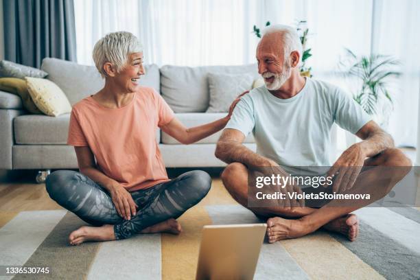 couple exercising together at home. - yoga at home stock pictures, royalty-free photos & images