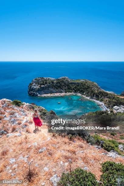 young woman in red skirt, view of anthony quinn bay, faliraki, rhodes, dodecanese, greece - anthony quinn bay stock pictures, royalty-free photos & images