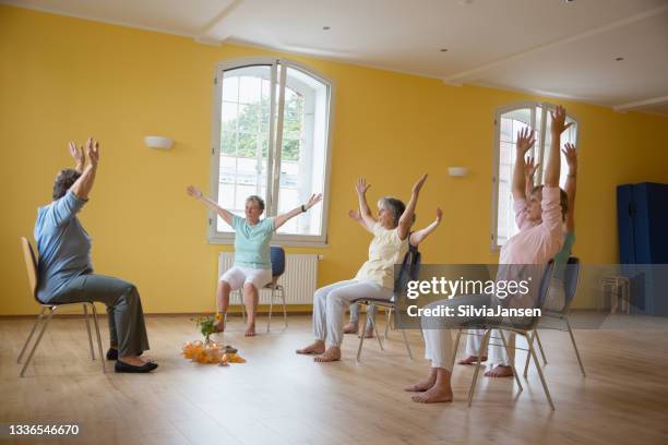 mulheres seniores ativas: aula de yoga em cadeiras - cadeira - fotografias e filmes do acervo