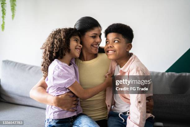 woman and two kids smiling at home - family with two children stock pictures, royalty-free photos & images