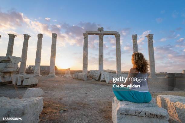 beautiful woman is meditating ,doing yoga in the ancient ruins of laodicea  during sunset - unesco 個照片及圖片檔