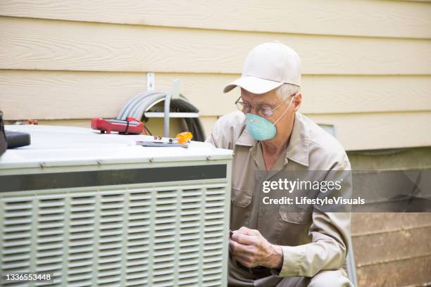 technician services outside ac unit. - ventilator mask stock pictures, royalty-free photos & images