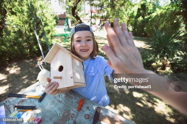 mutter und sohn bauen ein vogelhaus - vogelhäuschen stock-fotos und bilder