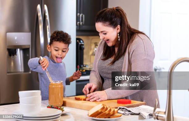 multi-ethnic mother, son making peanut butter sandwiches - peanut butter and jelly sandwich stock pictures, royalty-free photos & images