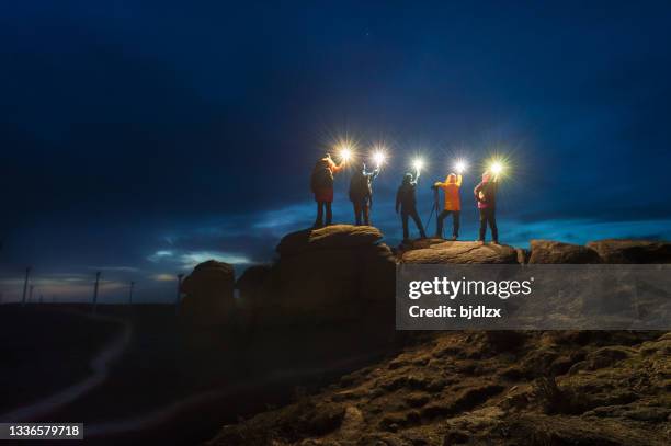 un gruppo di fotografi del cielo notturno in piedi sulla pietra con la lampada di notte - group adventure foto e immagini stock