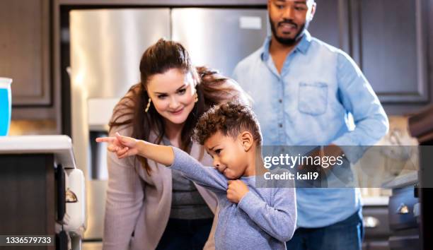 familia multiétnica, niño señalando algo que quiere - exigir fotografías e imágenes de stock