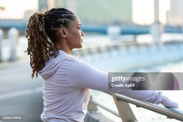 african-american woman stretching in city park - african cornrow braids stock pictures, royalty-free photos & images