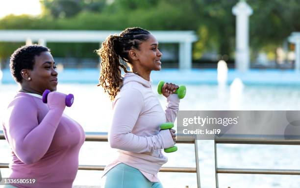 two african-american woman running together in city park - hand weight stock pictures, royalty-free photos & images