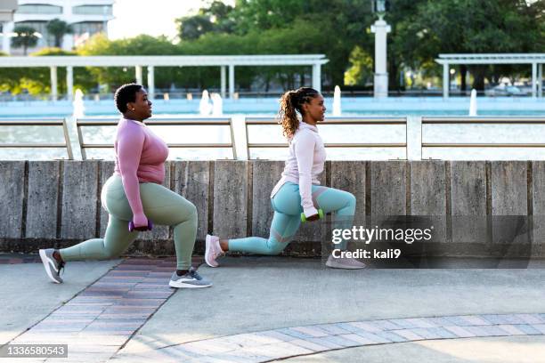 due donne afro-americane che fanno affondi nel parco cittadino - affondo foto e immagini stock