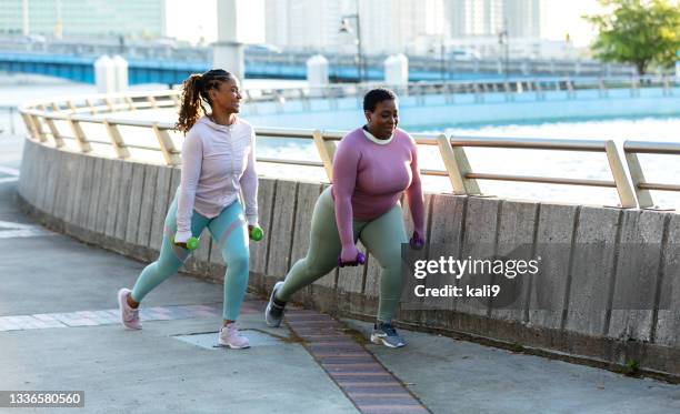 two african-american woman doing lunges in city park - 9:30 club stock pictures, royalty-free photos & images