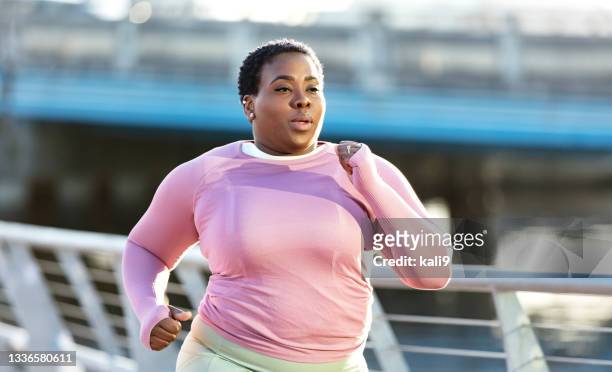african-american woman with large build, running in city - voluptuous black women stockfoto's en -beelden