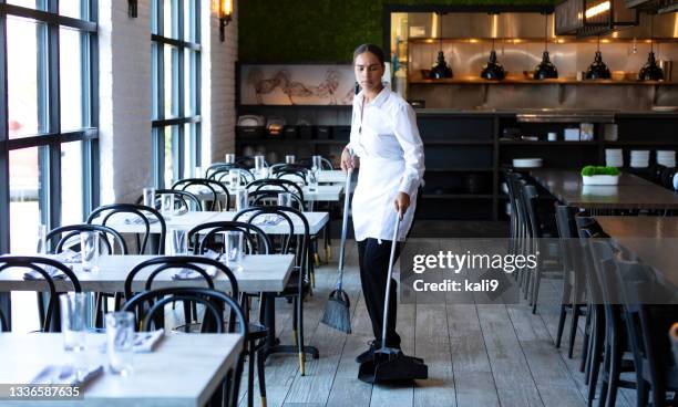 restaurant worker sweeping the floor - dustpan and brush stockfoto's en -beelden