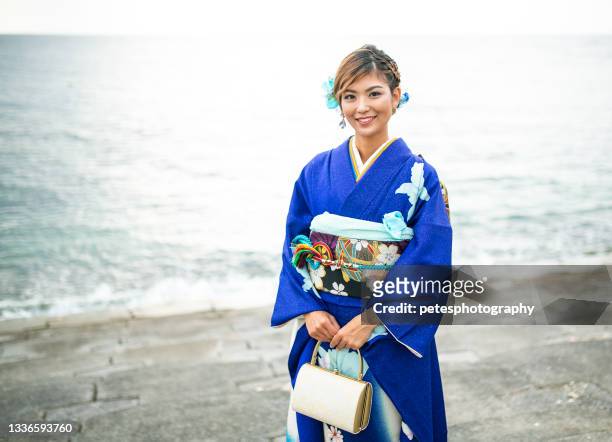a young japanese woman in kimono ocean background - seijin no hi stock pictures, royalty-free photos & images