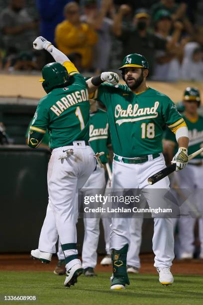 Josh Harrison of the Oakland Athletics celebrates with Mitch Moreland after hitting a solo home run in the bottom of the fifth inning against the New...