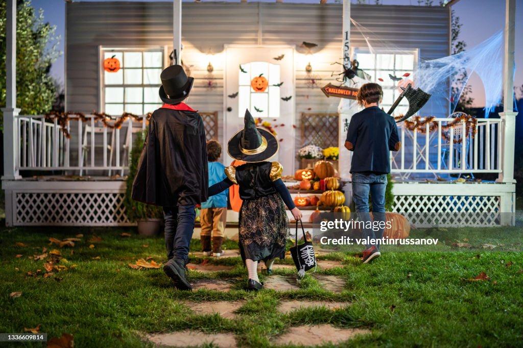 Young kids trick or treating at night during Halloween