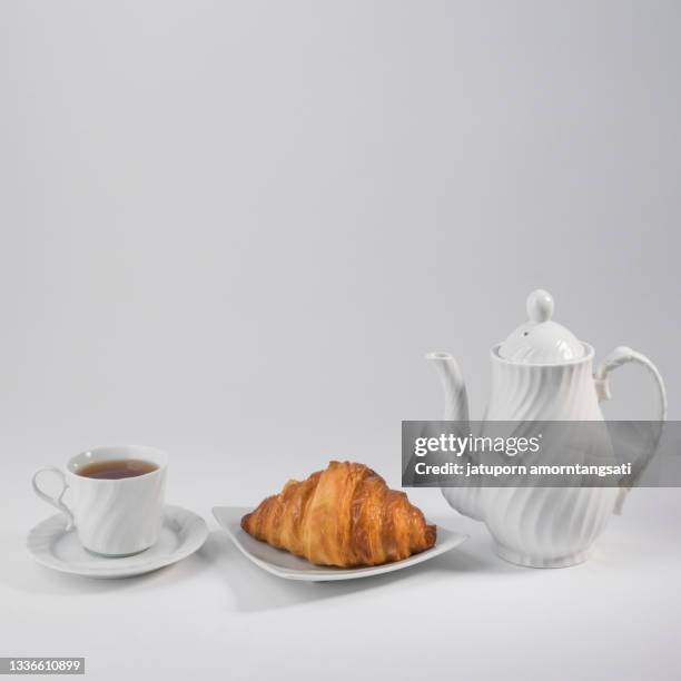 croissant with tea set - croissant white background stockfoto's en -beelden