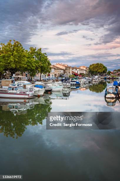 vertical view, cityscape reflected on still water, canal du rhône à sète, beaucaire, france. - rhone stock-fotos und bilder