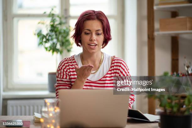 young woman with laptop using sign language indoors in office, video call concept. - hearing loss at work stock pictures, royalty-free photos & images