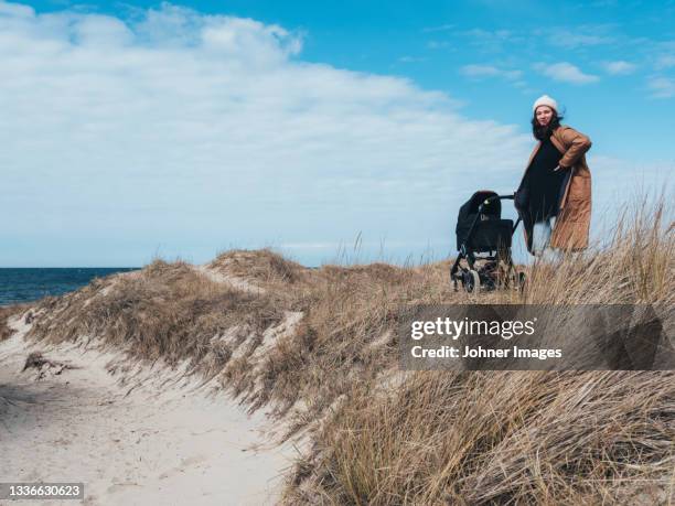 woman with pram standing on sand dunes - halland stock pictures, royalty-free photos & images