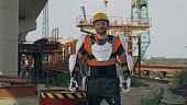 Male contractor in exoskeleton standing near barrel