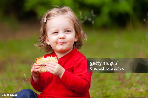 happy one year old girl enjoying cake - sponge cake stock pictures, royalty-free photos & images
