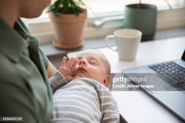 father holding baby son and working from home - intergénero fotografías e imágenes de stock