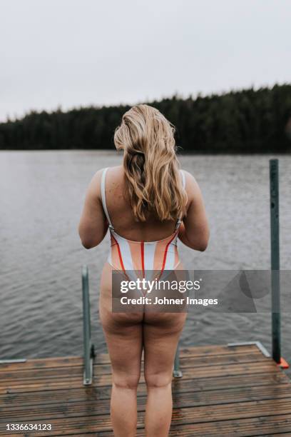 rear view of woman standing at jetty - bathing jetty stock pictures, royalty-free photos & images