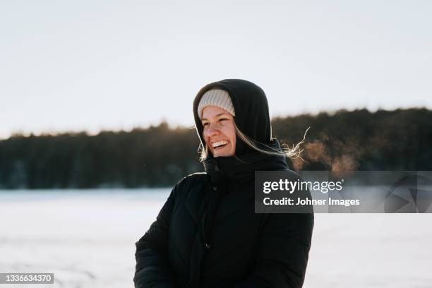 woman standing on frozen lake - landskap stockfoto's en -beelden