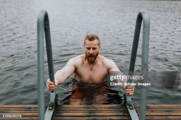 man in lake looking away - bathing jetty stock pictures, royalty-free photos & images