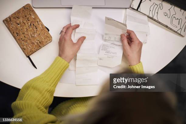 businesswoman checking receipts in office - johner images bildbanksfoton och bilder